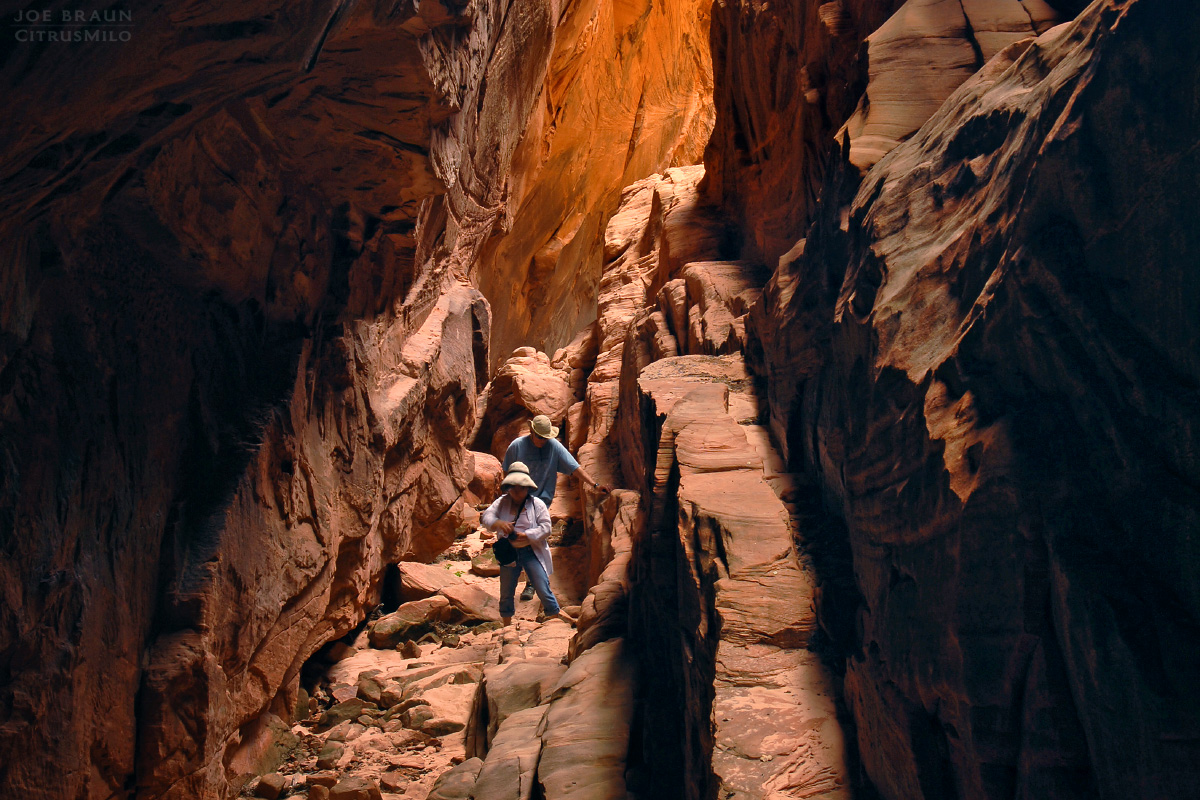 two hikers explore up the dark and narrow Shelf Canyon (Zion National Park) -- &copy; 2005 Joe Braun Photography